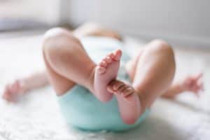 infant on blanket with feet up