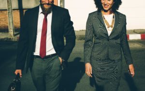 Man and woman in business suits, walking forward